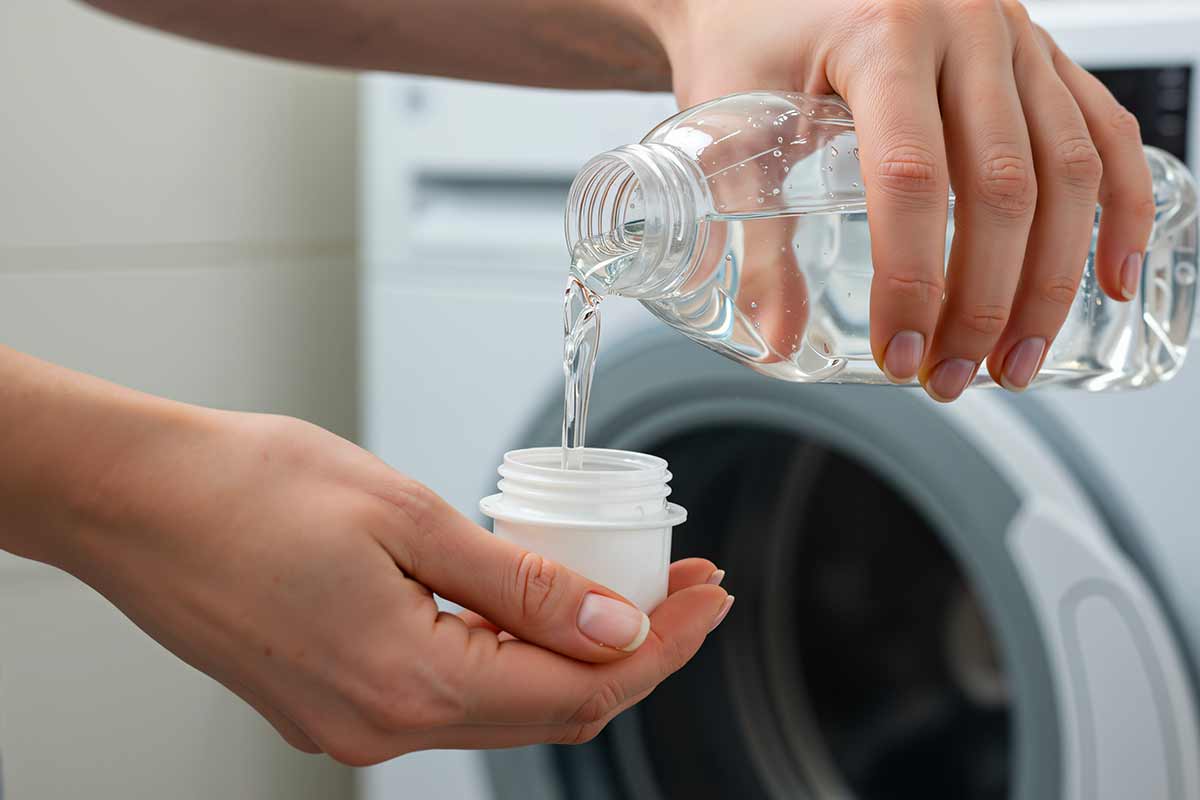 bicchiere di aceto nel cestello della lavatrice