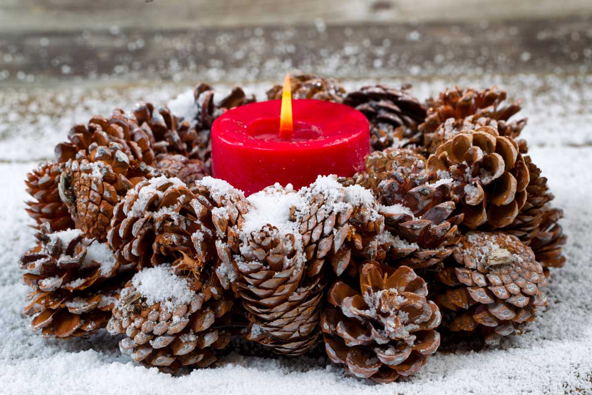 Centrotavola innevato con pigne e candela rossa