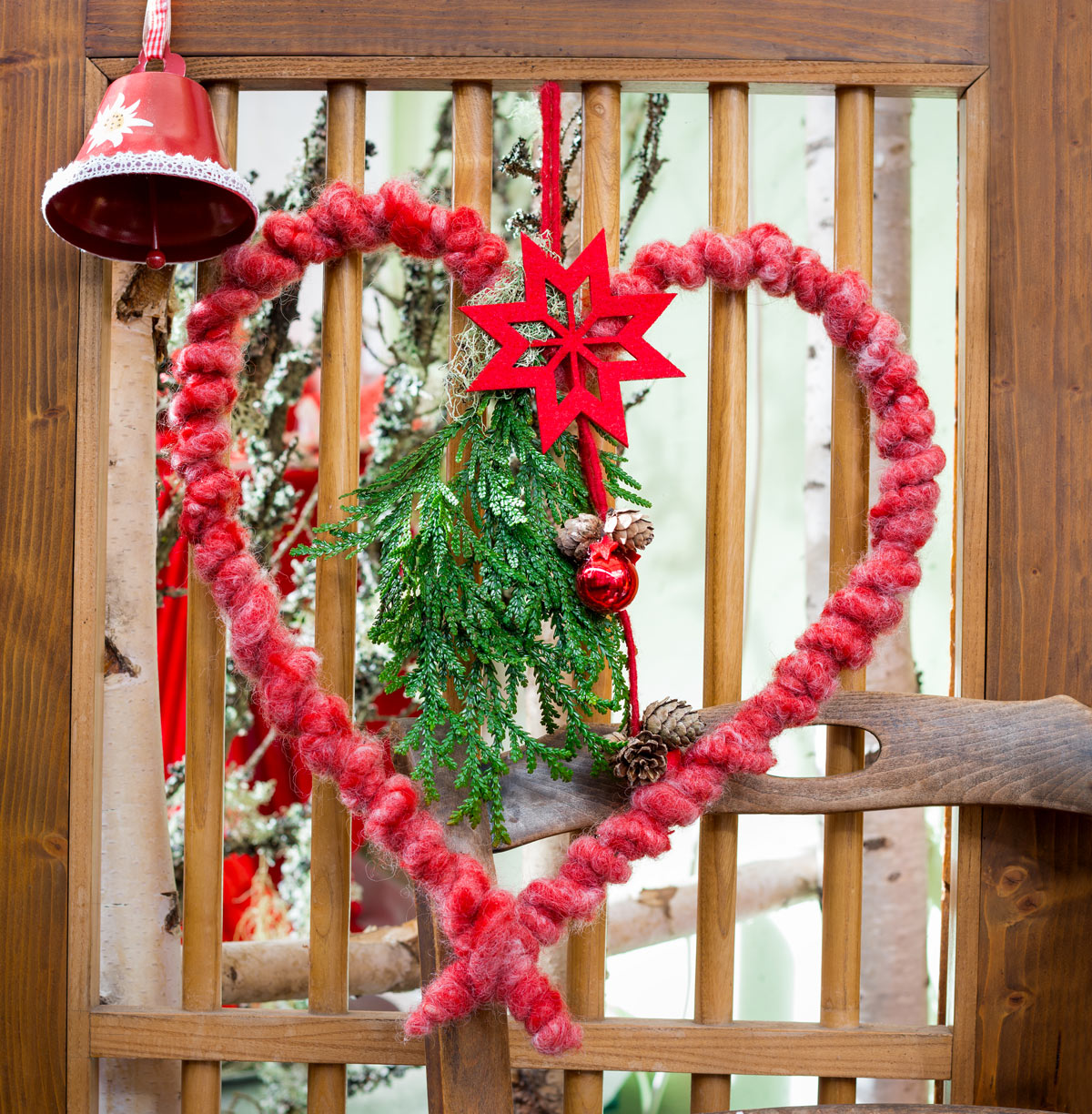 fuoriporta natalizio a fpra di cuore in lana rossa con elementi naturali