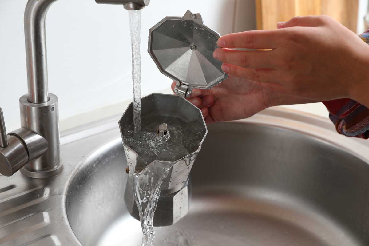 Donna lava la Moka a mano nel lavandino