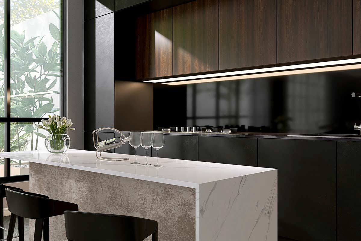 Cucina moderna con isola in marmo bianco, piani e mobili neri opachi, pensili in legno scuro e grande finestra che illumina l’ambiente con luce naturale. Sul piano, vaso di tulipani bianchi, calici e portabottiglia in metallo.