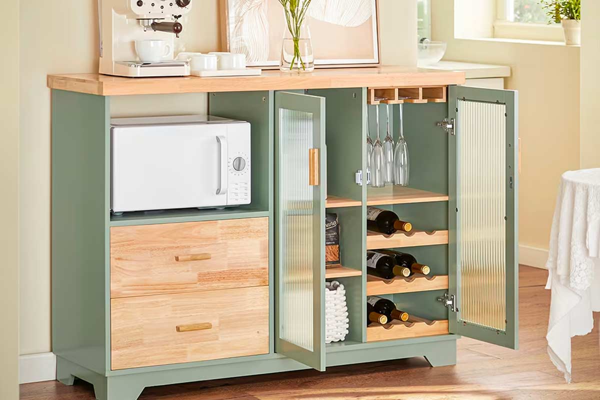 Buffet da cucina Maisons du Monde verde salvia e legno chiaro con ante in vetro, spazio microonde, cassetti, portabicchieri e portabottiglie, in ambiente luminoso e ordinato.