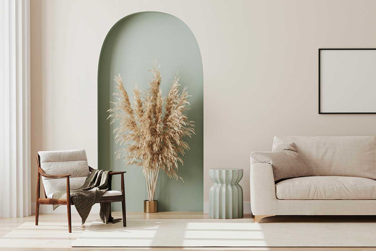 Soggiorno chiaro ed elegante con poltrona in legno, divano beige e nicchia verde pastello decorativa.