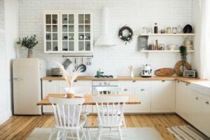 La cucina minimal che respira: bianco, legno chiaro, luci calde e pochi elementi davvero giusti