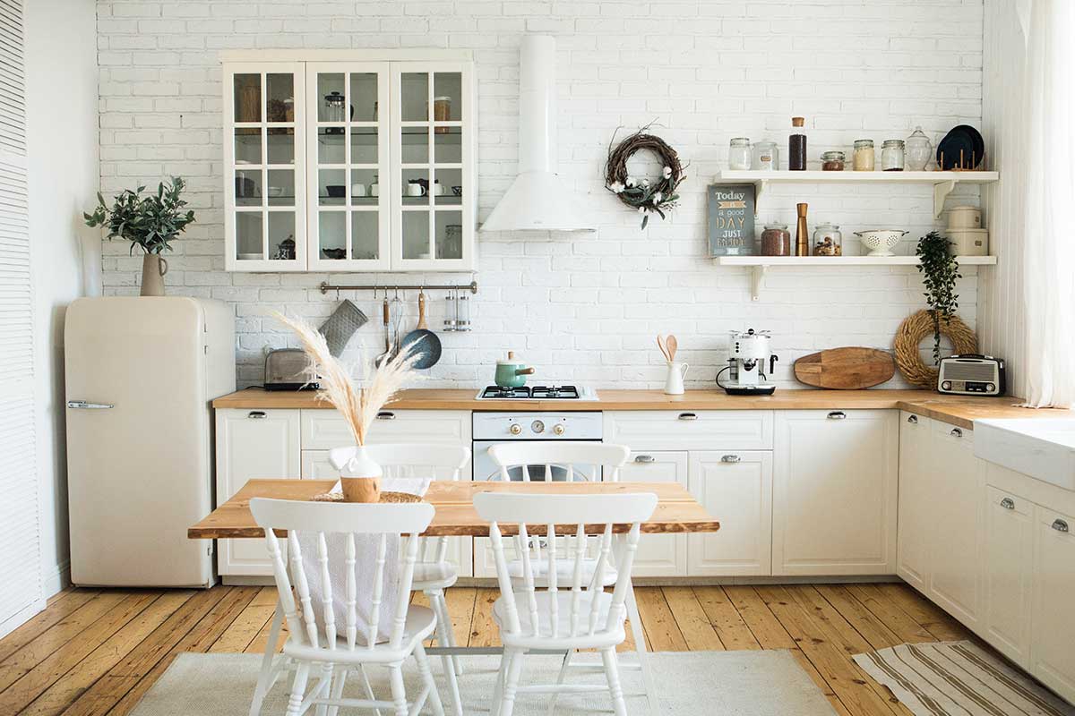 La cucina minimal che respira: bianco, legno chiaro, luci calde e pochi elementi davvero giusti
