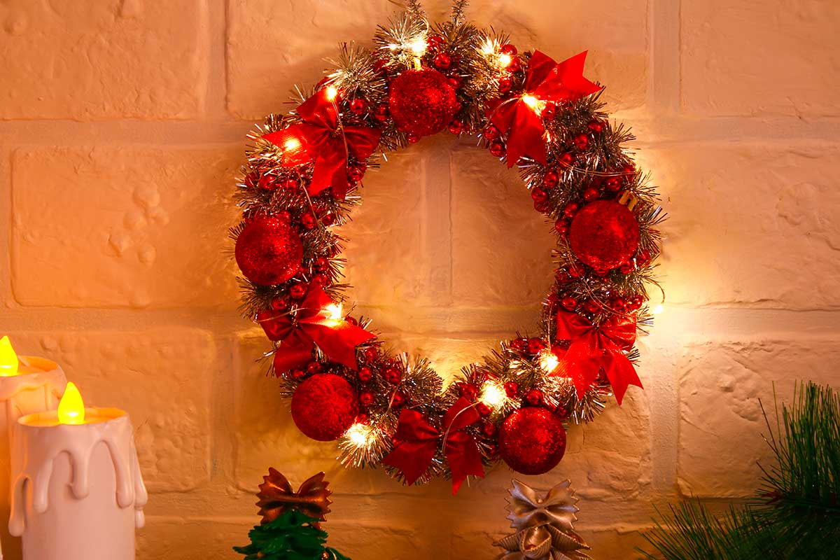 Corona classica con sfere rosse, fiocchi e lucine