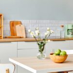 Quale colore alle pareti per una cucina bianca e legno? Le 4 tonalità che esaltano le venature del piano Cucina bianca e legno con parete verde salvia chiaro e dettagli coordinati, foto di © Seventyfour - stock.adobe.com