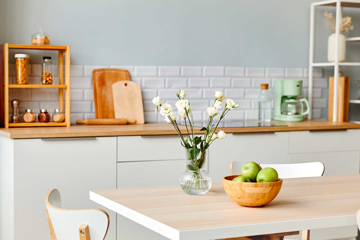 Cucina bianca e legno con parete verde salvia chiaro e dettagli coordinati, foto di © Seventyfour - stock.adobe.com