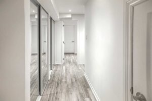 Corridoio luminoso con armadio a muro con specchi.