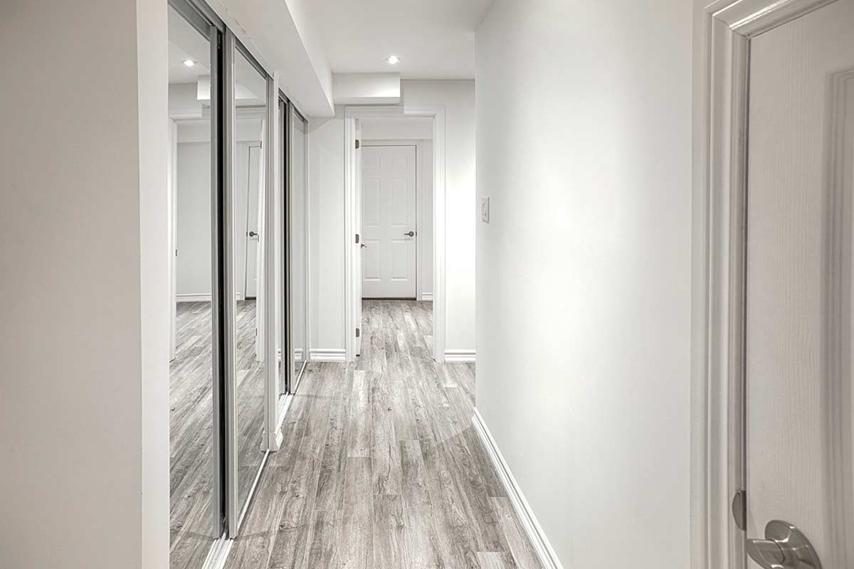 Corridoio luminoso con armadio a muro con specchi.