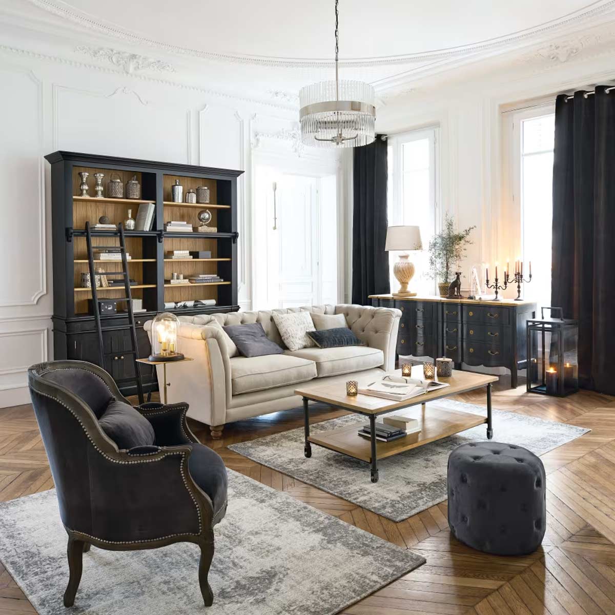 Salotto in stile parigino con libreria Versailles nera di Maisons du Monde, scala scorrevole e dettagli in ottone anticato.
