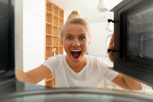 Donna guarda dentro un microonde e trova il punto nascosto da pulire