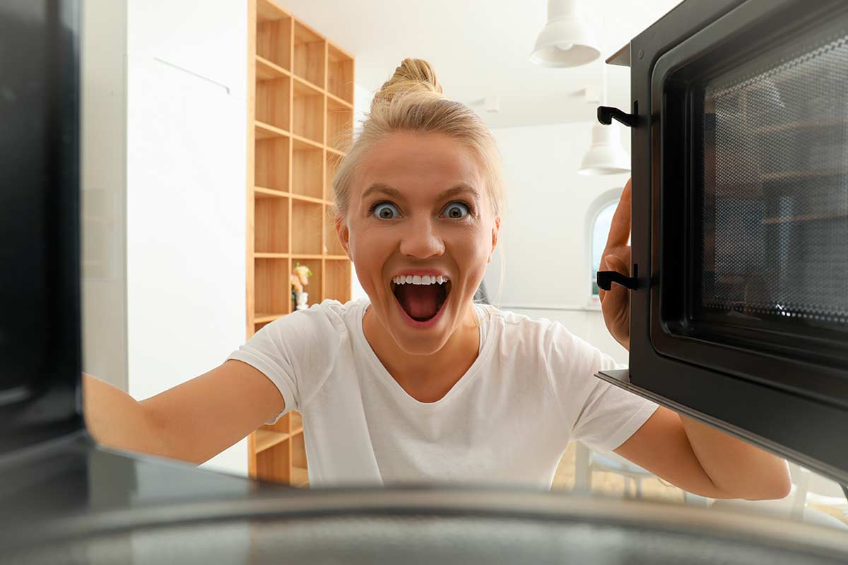 Donna guarda dentro un microonde e trova il punto nascosto da pulire