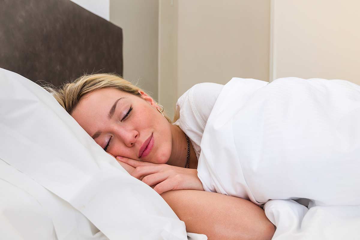 Donna che dorme mentre le griglie del forno si sgrassano da solo.