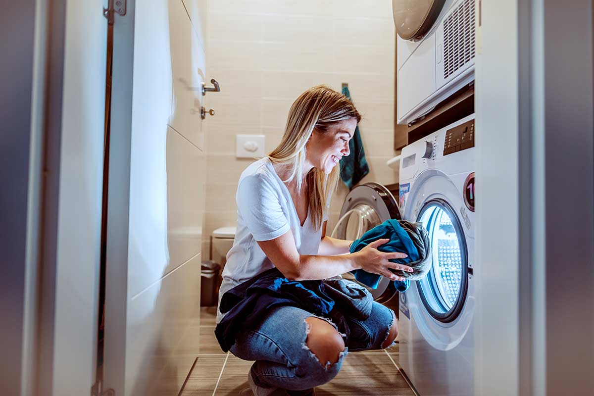 Donna che carica la lavatrice con la regola del carico libero
