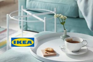 Tavolino IKEA Gladom bianco con vassoio amovibile utilizzato come vassoio da colazione con tazza di tè e biscotto in un salotto moderno.