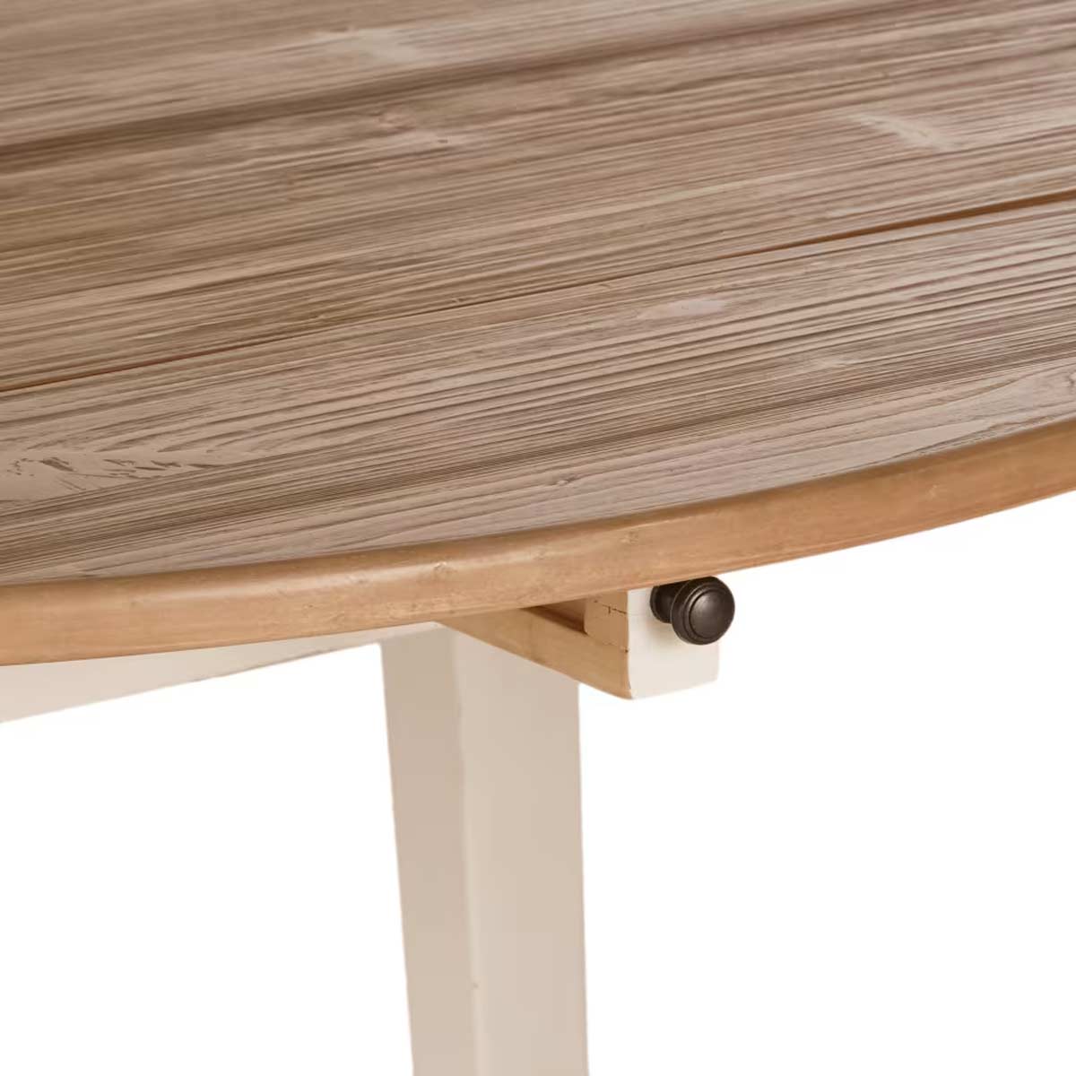 Dettaglio del bordo e della superficie in legno massello del tavolo rotondo Provence di Maisons du Monde, con particolare del sistema allungabile integrato sotto il piano.