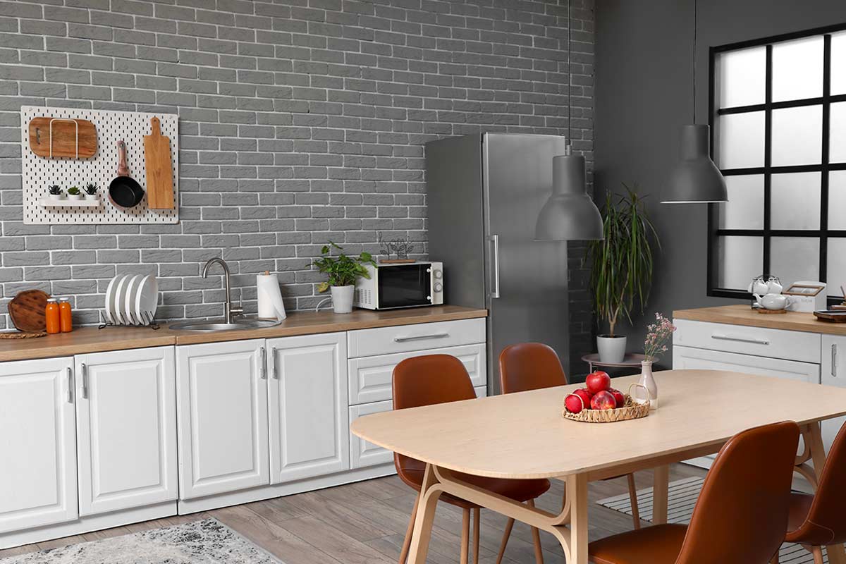 Sedie Terracotta e parete Grigio Antracite: il bianco e legno trovano carattere e profondità senza perdere luminosità.