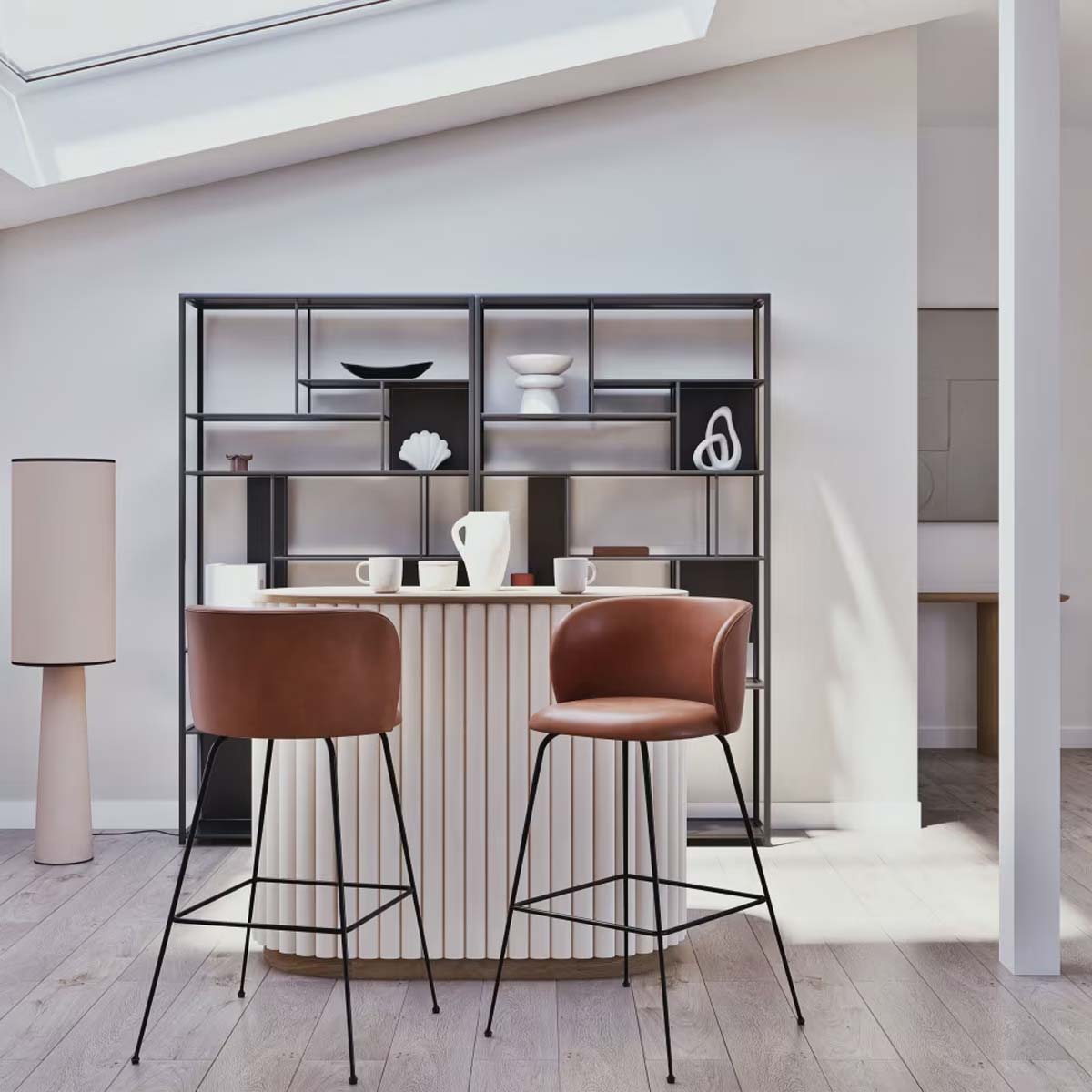 Mobile bar bicolore Caldera di Maisons du Monde inserito in un soggiorno moderno, con due sgabelli in pelle marrone e libreria in metallo nero sullo sfondo. La luce naturale evidenzia le superfici e i dettagli del mobile, creando un ambiente elegante e funzionale.