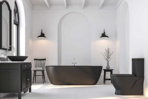 Bagno moderno total white con sanitari, vasca e dettagli nero opaco, illuminato da luce naturale.