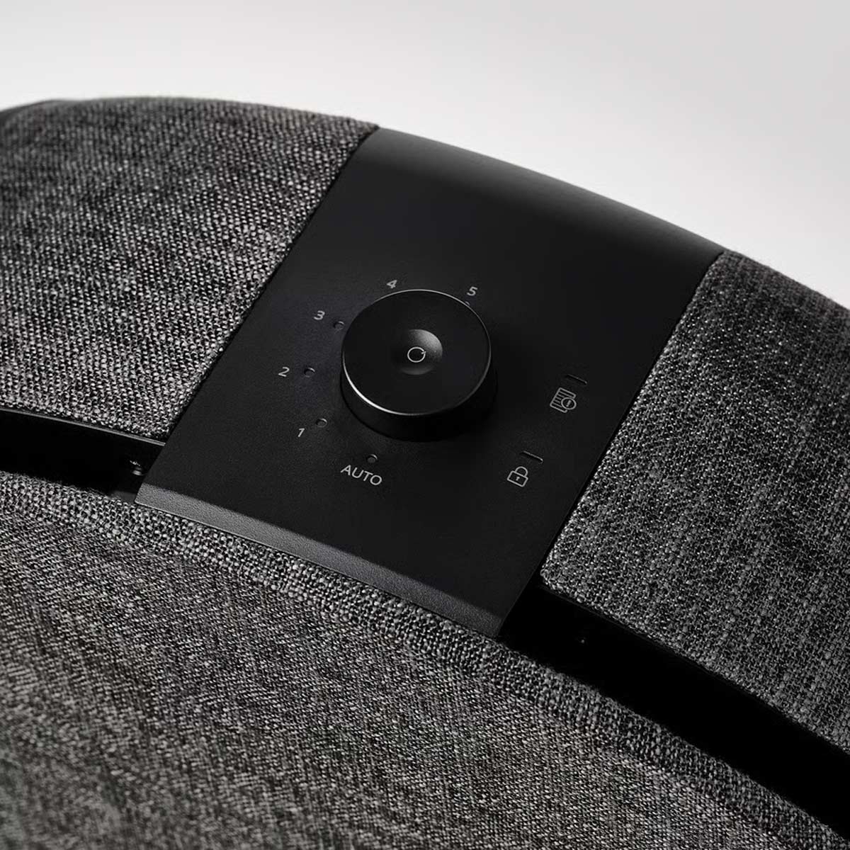 Primo piano del pannello di controllo del purificatore d’aria STARKVIND di IKEA, con manopola centrale, indicatori delle velocità e rivestimento in tessuto grigio.