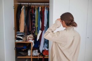 Donna guada il suo armadio pieno.