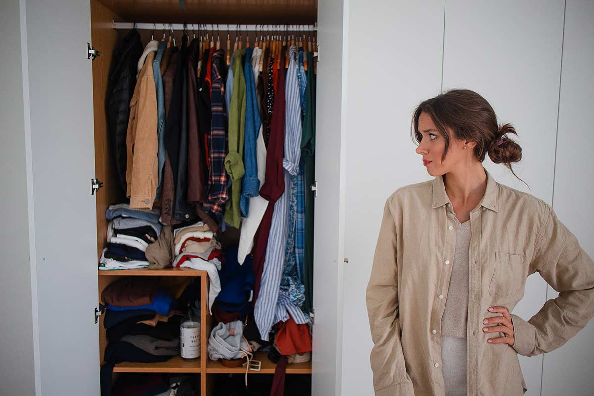 donna guarda il suo armadio prima di svuotarlo