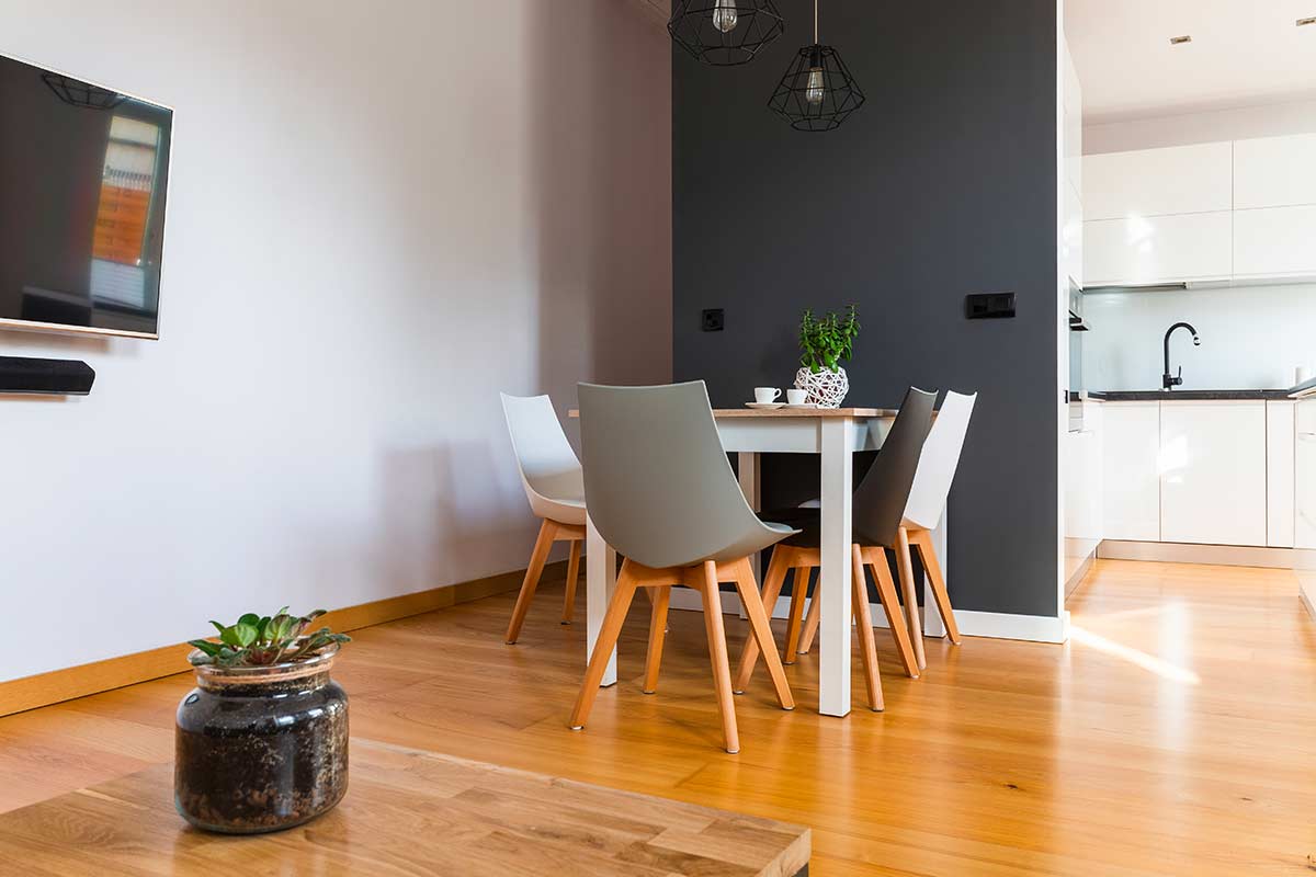 Zona pranzo separata dal soggiorno con parete color grigio scuro in stile Color Blocking.