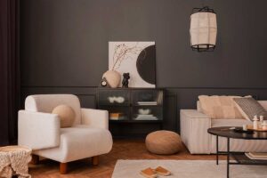 Soggiorno elegante con parete nera, poltrona chiara e arredi neutri che creano contrasto e profondità senza rimpicciolire lo spazio.