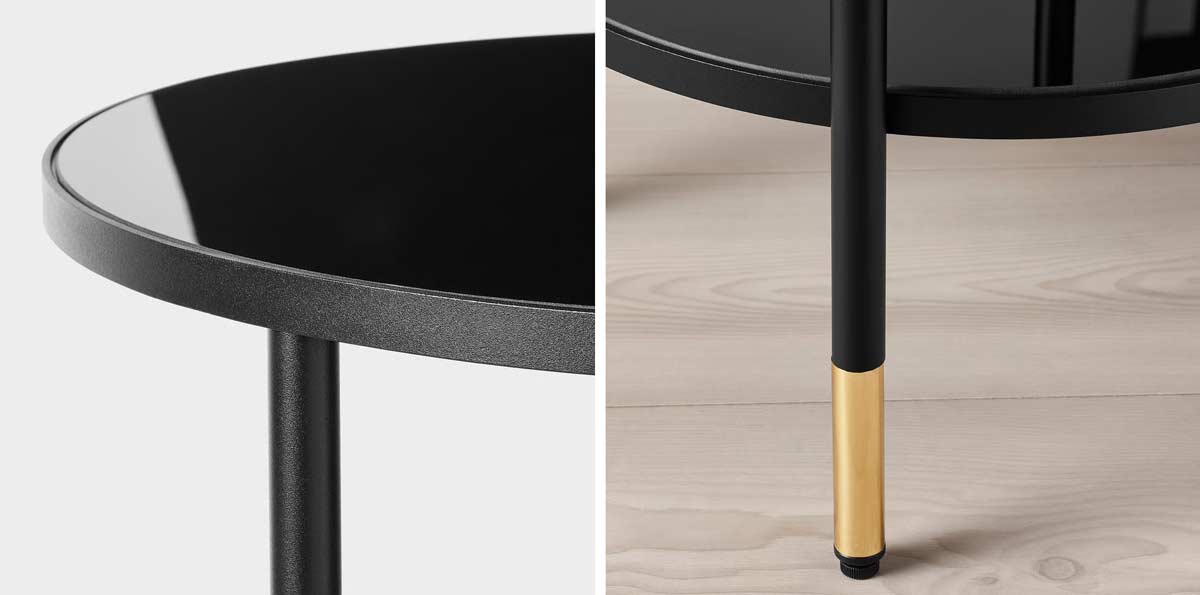 Dettaglio ravvicinato del tavolino IKEA ÄSPERÖD: piano in vetro nero fumé e gambe in metallo con terminali dorati.