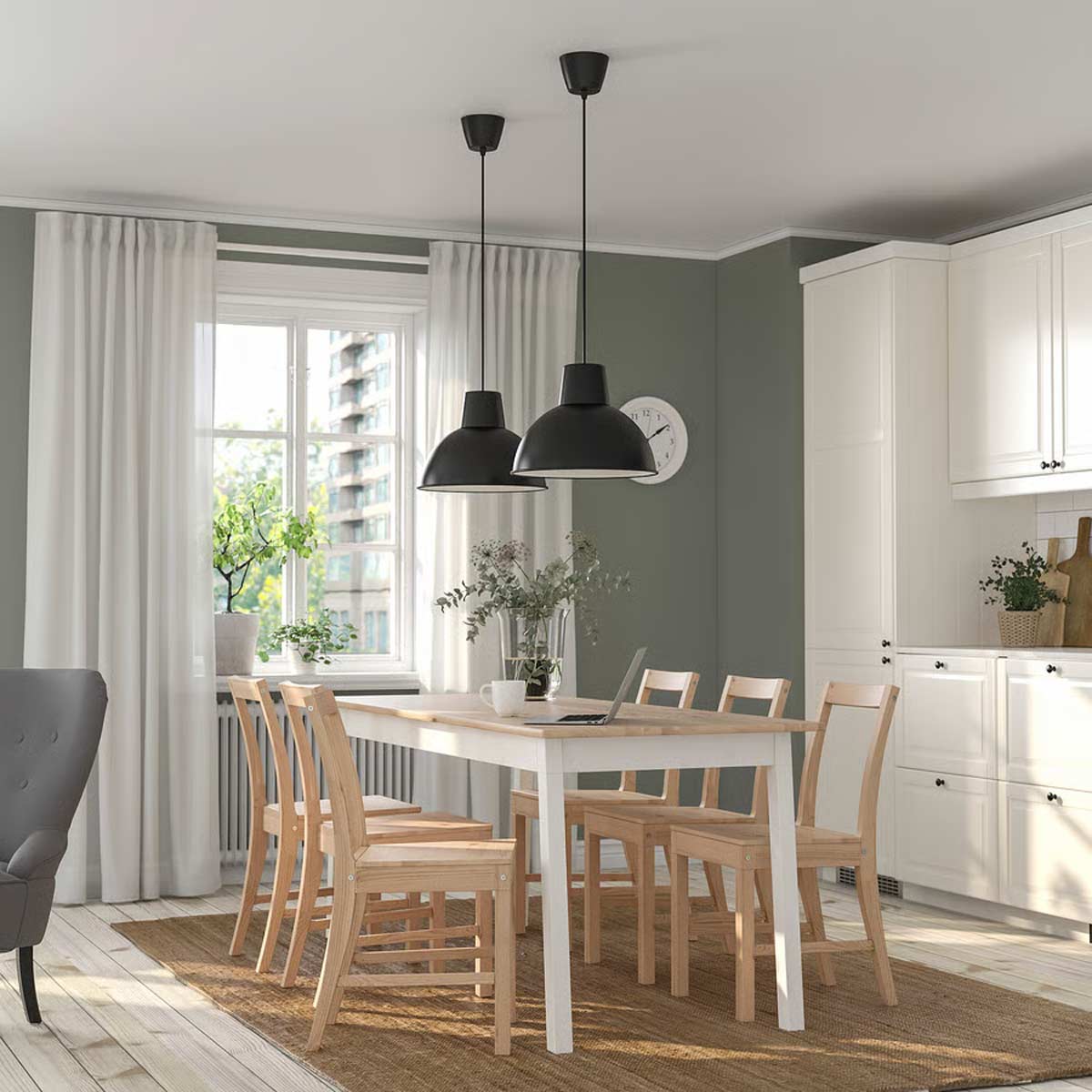 Sala da pranzo con tavolo PINNTORP IKEA in legno chiaro, sei sedie coordinate e lampade nere sospese in ambiente luminoso.