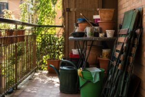 Balcone piccolo usato come ripostiglio con sedie e vasi accumulati