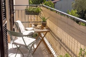 Balcone piccolo con zona d'ombra mobile in estate