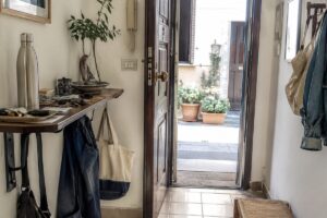 Ingresso piccolo con ripiano pieno di oggetti che rende lo spazio più soffocante