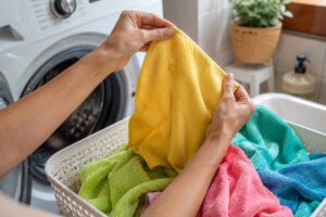 Panni in microfibra in un cesto vicino alla lavatrice con odore dopo il lavaggio