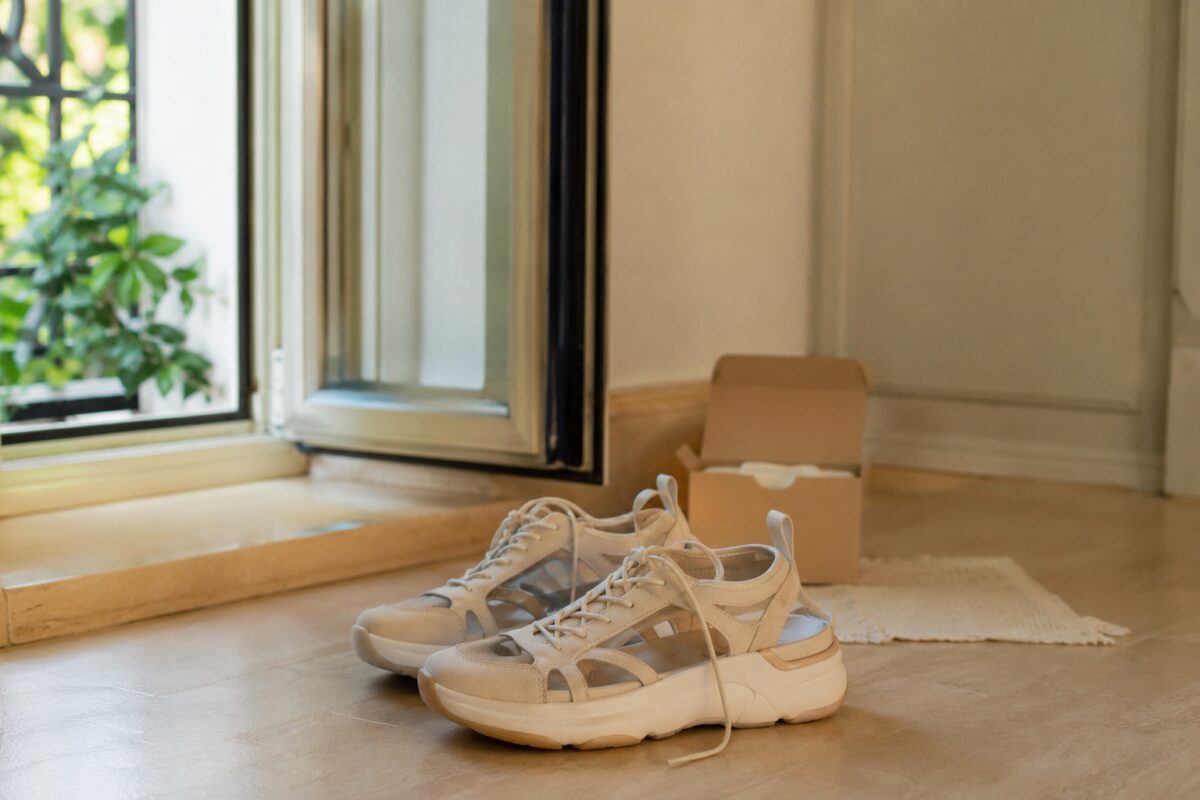 Scarpe da ginnastica aperte all’aria vicino a una finestra con bicarbonato sullo sfondo