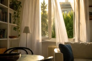 Tende leggere alla finestra con polvere visibile in controluce
