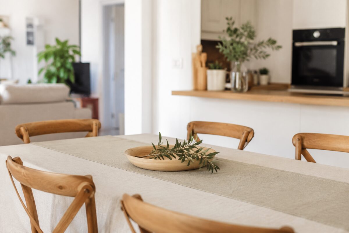 Tavolo da pranzo ordinato con centrotavola leggero e superficie libera